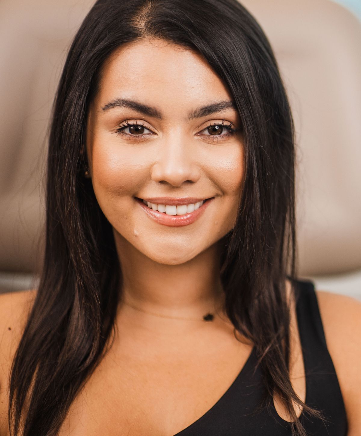 Smiling woman with long dark hair.