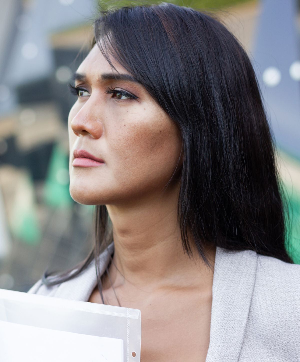 Person looking thoughtfully while holding documents.