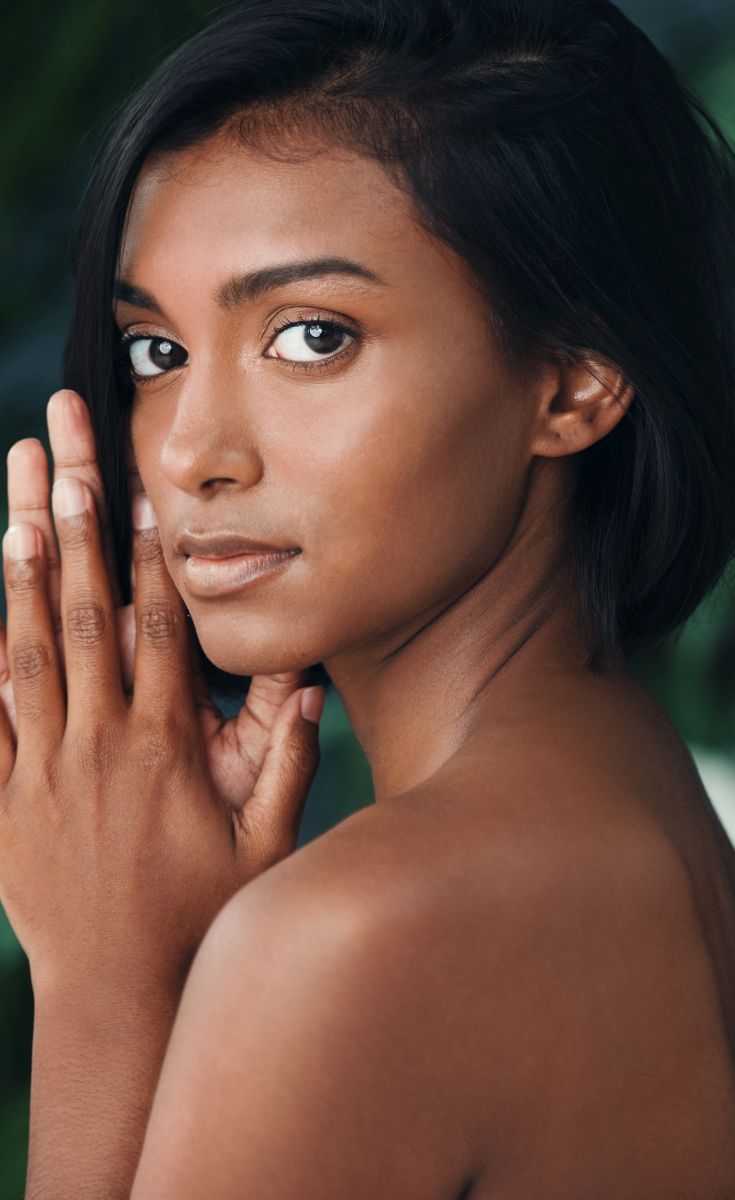 Portrait of a woman with hands posed elegantly.