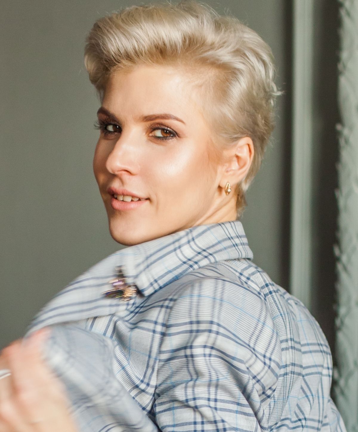 Person with short blonde hair in plaid shirt.